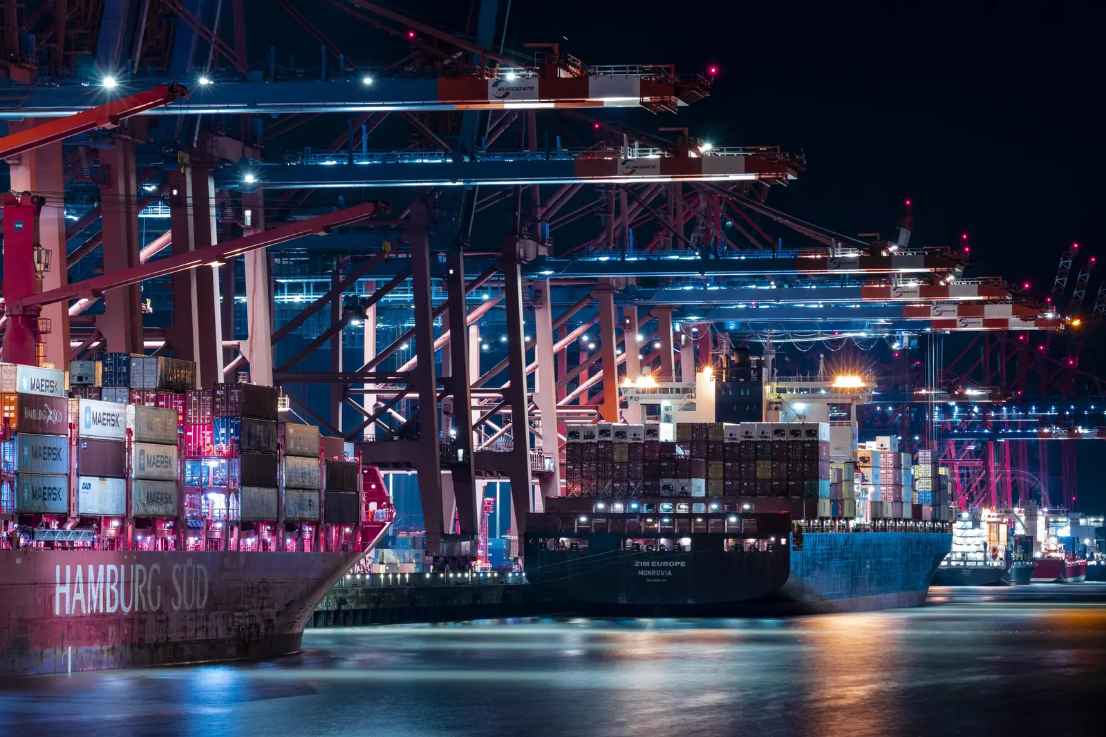 Containerterminal im Hamburger Hafen bei Nacht mit Frachtern von Hamburg Süd und ZIM