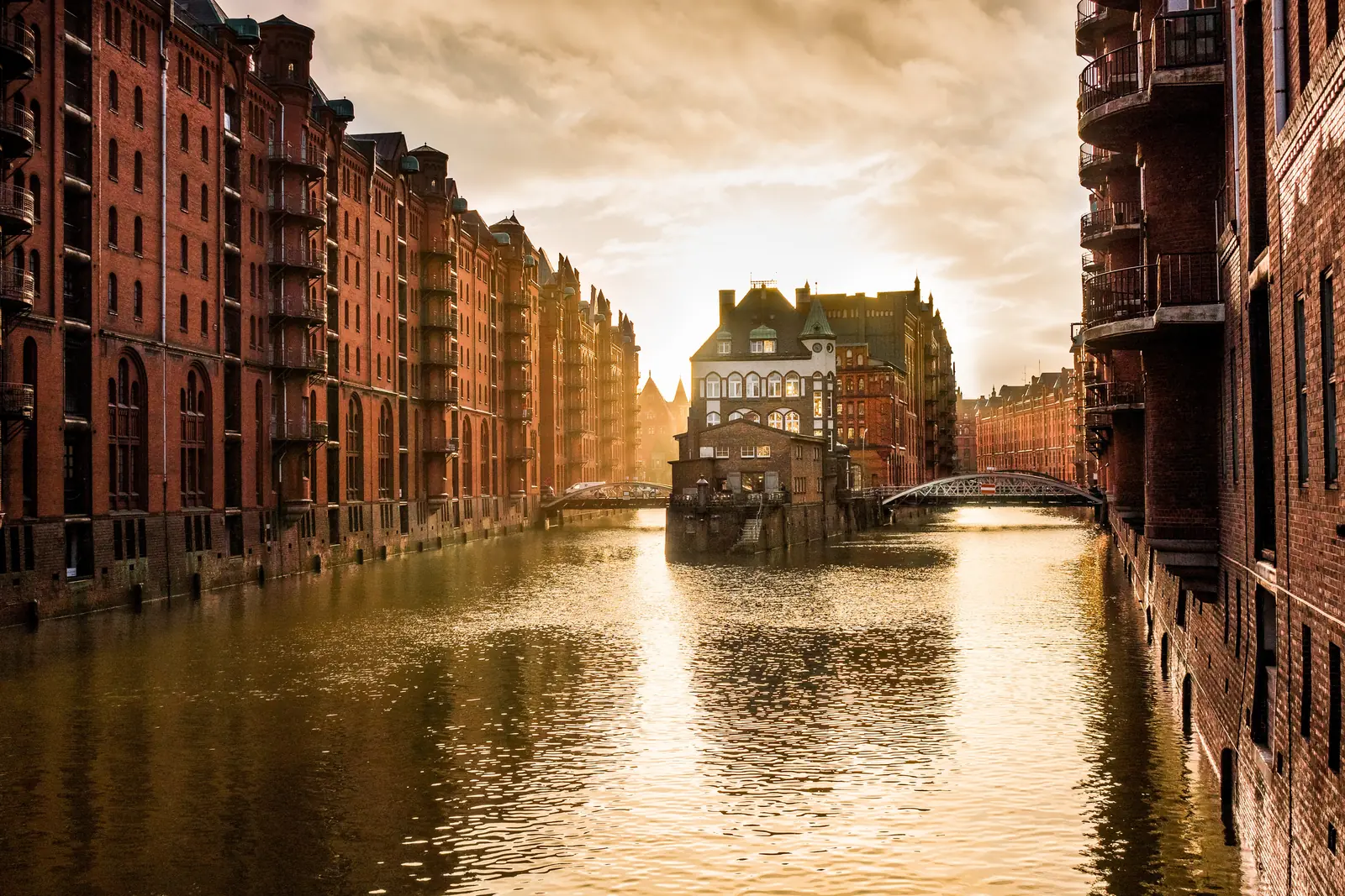 Speicherstadt Hamburg im goldenen Abendlicht mit Wasserschloss und Brücken